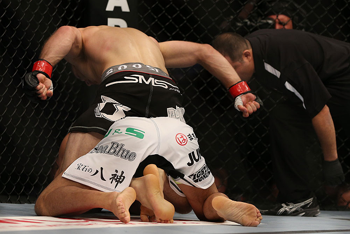 DENVER, CO - AUGUST 11: Nik Lentz (black shorts) punches down at Eiji Mitsuoka during their featherweight bout at UFC 150 inside Pepsi Center on August 11, 2012 in Denver, Colorado. (Photo by Josh Hedges/Zuffa LLC/Zuffa LLC via Getty Images)