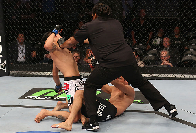 DENVER, CO - AUGUST 11: Referee Herb Dean steps in to stop the bout as Erik Perez (L) knocks out Ken Stone during their bantamweight bout at UFC 150 inside Pepsi Center on August 11, 2012 in Denver, Colorado. (Photo by Nick Laham/Zuffa LLC/Zuffa LLC via