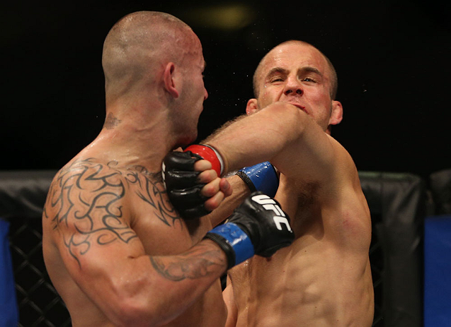 DENVER, CO - AUGUST 11: (L-R) Michael Kuiper knocks down Jared Hamman with a punch during their middleweight bout at UFC 150 inside Pepsi Center on August 11, 2012 in Denver, Colorado. (Photo by Josh Hedges/Zuffa LLC/Zuffa LLC via Getty Images)