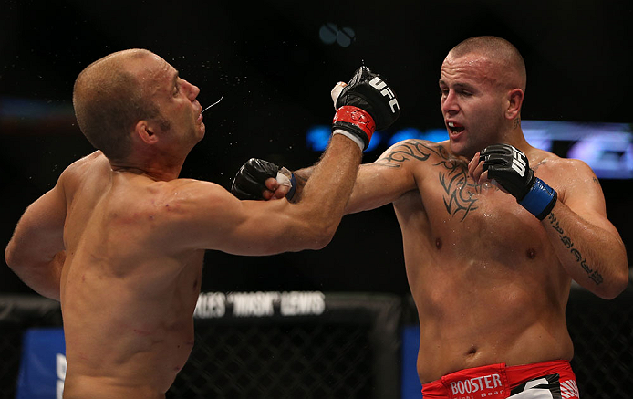 DENVER, CO - AUGUST 11: (R-L) Michael Kuiper knocks down Jared Hamman with a punch during their middleweight bout at UFC 150 inside Pepsi Center on August 11, 2012 in Denver, Colorado. (Photo by Josh Hedges/Zuffa LLC/Zuffa LLC via Getty Images)
