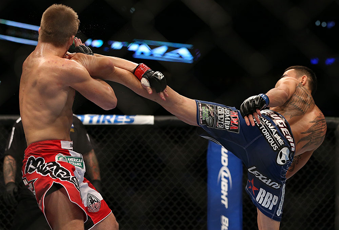 DENVER, CO - AUGUST 11: (R-L) Max Holloway kicks Justin Lawrence during their featherweight bout at UFC 150 inside Pepsi Center on August 11, 2012 in Denver, Colorado. (Photo by Josh Hedges/Zuffa LLC/Zuffa LLC via Getty Images)