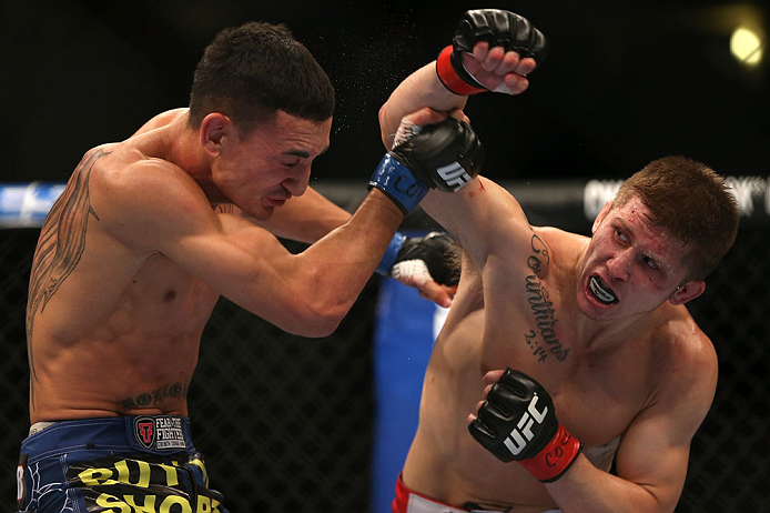 DENVER, CO - AUGUST 11: (R-L) Justin Lawrence punches Max Holloway during their featherweight bout at UFC 150 inside Pepsi Center on August 11, 2012 in Denver, Colorado. (Photo by Josh Hedges/Zuffa LLC/Zuffa LLC via Getty Images)