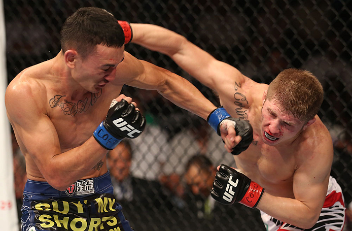 DENVER, CO - AUGUST 11: (L-R) Max Holloway and Justin Lawrence trade punches during their featherweight bout at UFC 150 inside Pepsi Center on August 11, 2012 in Denver, Colorado. (Photo by Nick Laham/Zuffa LLC/Zuffa LLC via Getty Images)