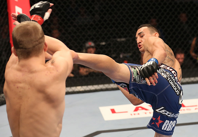 DENVER, CO - AUGUST 11: (R-L) Max Holloway kicks Justin Lawrence during their featherweight bout at UFC 150 inside Pepsi Center on August 11, 2012 in Denver, Colorado. (Photo by Nick Laham/Zuffa LLC/Zuffa LLC via Getty Images)
