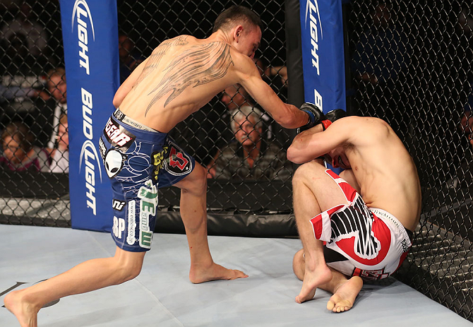 DENVER, CO - AUGUST 11: (L-R) Max Holloway punches Justin Lawrence during their featherweight bout at UFC 150 inside Pepsi Center on August 11, 2012 in Denver, Colorado. (Photo by Nick Laham/Zuffa LLC/Zuffa LLC via Getty Images)
