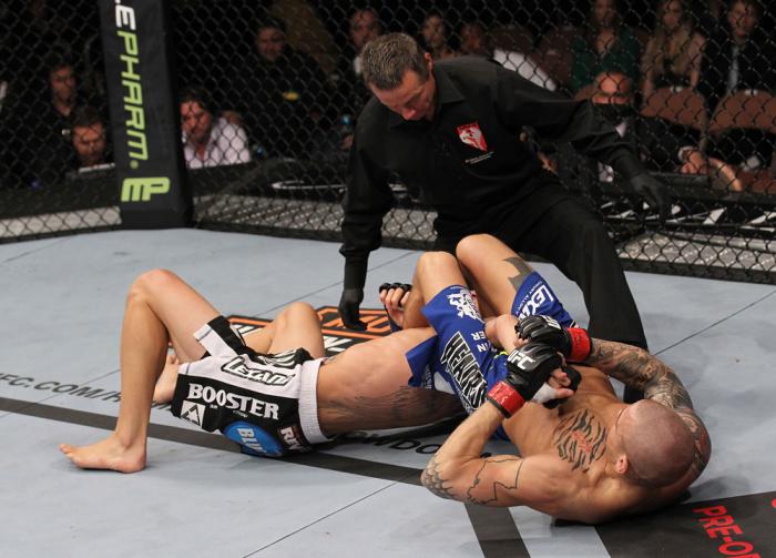 LAS VEGAS, NV - FEBRUARY 04: Dustin Poirier (right) attempts to submit Max Holloway as referee Steve Mazzagatti looks on during the UFC 143 event at Mandalay Bay Events Center on February 4, 2012 in Las Vegas, Nevada. (Photo by Nick Laham/Zuffa LLC/Zuff