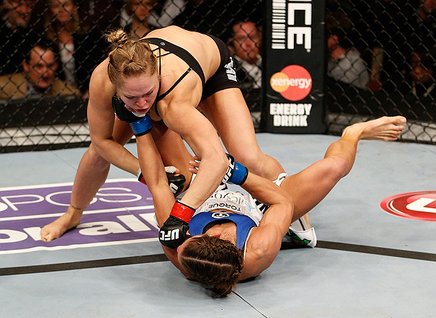 ANAHEIM, CA - FEBRUARY 23: Ronda Rousey (top) punches Liz Carmouche in their women's bantamweight title fight during UFC 157 at Honda Center on February 23, 2013 in Anaheim, California. (Photo by Josh Hedges/Zuffa LLC/Zuffa LLC via Getty Images) *** Loc