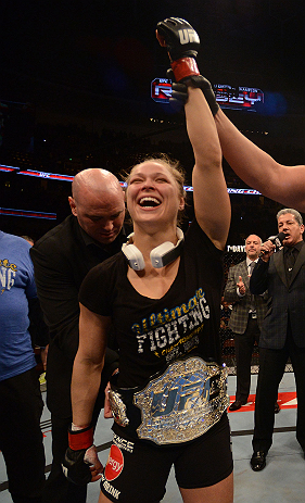 ANAHEIM, CA - FEBRUARY 23: UFC President Dana White (rear) puts the UFC women's bantamweight title belt around Ronda Rousey after women's bantamweight title fight during UFC 157 at Honda Center on February 23, 2013 in Anaheim, California. (Photo by Dona