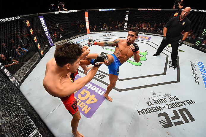 NEW ORLEANS, LA - JUNE 06: (R-L) Thiago Tavares kicks Brian Ortega in their featherweight bout during the UFC event at the Smoothie King Center on June 6, 2015 in New Orleans, Louisiana. (Photo by Josh Hedges/Zuffa LLC/Zuffa LLC via Getty Images)