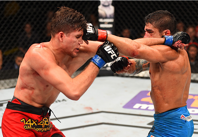 NEW ORLEANS, LA - JUNE 06: (R-L) Thiago Tavares exchanges punches with Brian Ortega in their featherweight bout during the UFC event at the Smoothie King Center on June 6, 2015 in New Orleans, Louisiana. (Photo by Josh Hedges/Zuffa LLC/Zuffa LLC via Get