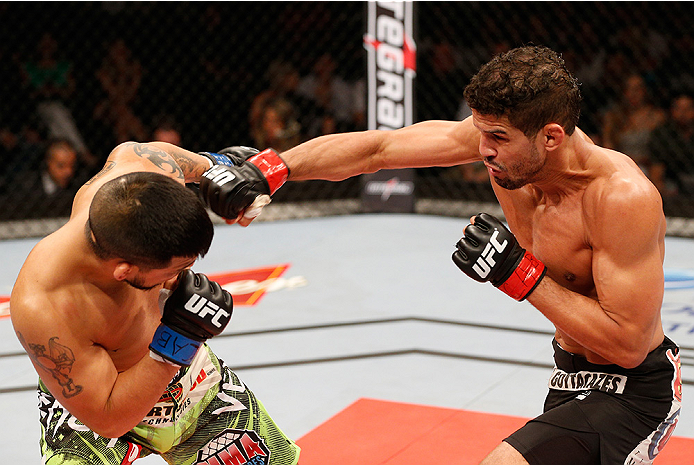 BRASILIA, BRAZIL - SEPTEMBER 13: (R-L) Leonardo Santos of Brazil punches Efrain Escudero of Mexico in their lightweight bout during the UFC Fight Night event inside Nilson Nelson Gymnasium on September 13, 2014 in Brasilia, Brazil. (Photo by Josh Hedge