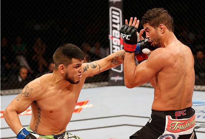 BRASILIA, BRAZIL - SEPTEMBER 13: (L-R) Efrain Escudero of Mexico punches Leonardo Santos of Brazil in their lightweight bout during the UFC Fight Night event inside Nilson Nelson Gymnasium on September 13, 2014 in Brasilia, Brazil. (Photo by Josh Hedge