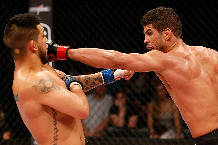 BRASILIA, BRAZIL - SEPTEMBER 13: (R-L) Leonardo Santos of Brazil punches Efrain Escudero of Mexico in their lightweight bout during the UFC Fight Night event inside Nilson Nelson Gymnasium on September 13, 2014 in Brasilia, Brazil. (Photo by Josh Hedges/Z