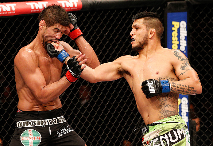 BRASILIA, BRAZIL - SEPTEMBER 13: (R-L) Efrain Escudero of Mexico punches Leonardo Santos of Brazil in their lightweight bout during the UFC Fight Night event inside Nilson Nelson Gymnasium on September 13, 2014 in Brasilia, Brazil. (Photo by Josh Hedge