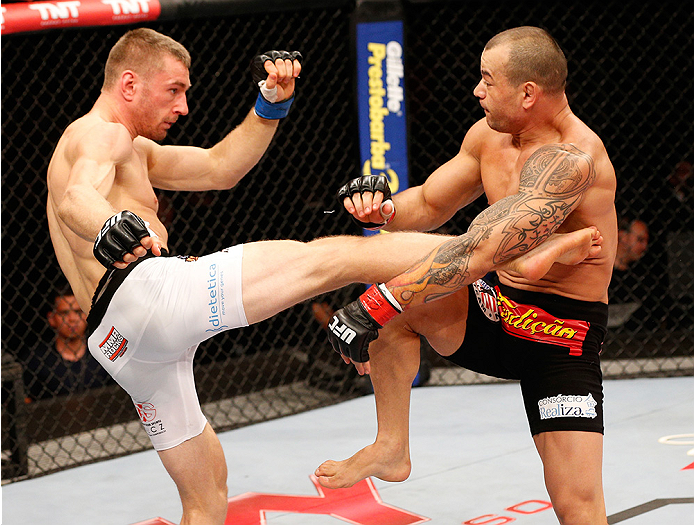 BRASILIA, BRAZIL - SEPTEMBER 13: (L-R) Piotr Hallmann of Poland kicks Gleison Tibau of Brazil in their lightweight bout during the UFC Fight Night event inside Nilson Nelson Gymnasium on September 13, 2014 in Brasilia, Brazil. (Photo by Josh Hedges/Zuffa