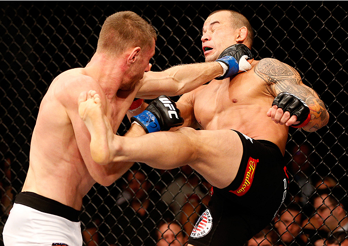 BRASILIA, BRAZIL - SEPTEMBER 13: (L-R) Piotr Hallmann of Poland punches Gleison Tibau of Brazil in their lightweight bout during the UFC Fight Night event inside Nilson Nelson Gymnasium on September 13, 2014 in Brasilia, Brazil. (Photo by Josh Hedges/Zuff