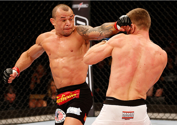 BRASILIA, BRAZIL - SEPTEMBER 13: (L-R) Gleison Tibau of Brazil lands a spinning back fist against Piotr Hallmann of Poland in their lightweight bout during the UFC Fight Night event inside Nilson Nelson Gymnasium on September 13, 2014 in Brasilia, Brazil.