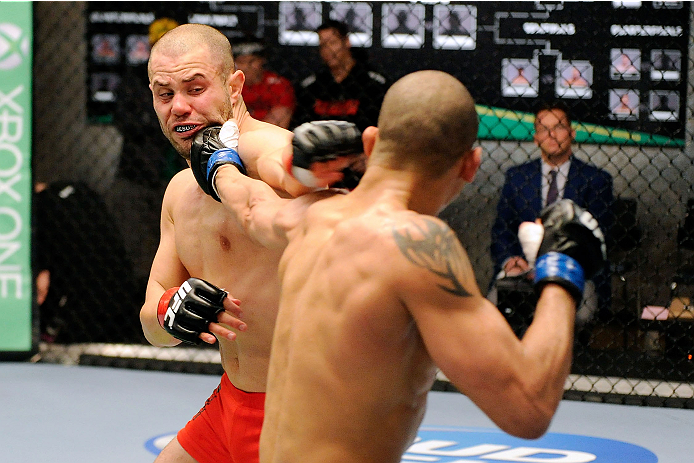 LACHUTE, CANADA - DECEMBER 6: (R-L) Team Canada fighter Kajan Johnson punches Team Canada fighter Chad Laprise in their semifinal middleweight fight during filming of The Ultimate Fighter Nations television series on December 6, 2013 in Lachute, Quebec,