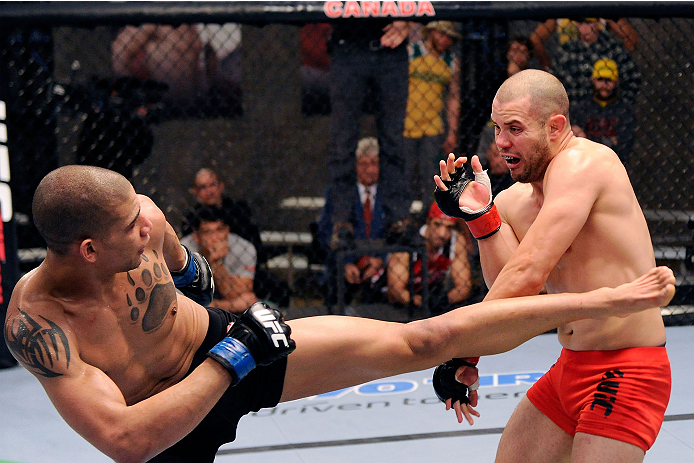 LACHUTE, CANADA - DECEMBER 6: (L-R) Team Canada fighter Kajan Johnson kicks Team Canada fighter Chad Laprise in their semifinal middleweight fight during filming of The Ultimate Fighter Nations television series on December 6, 2013 in Lachute, Quebec, Ca