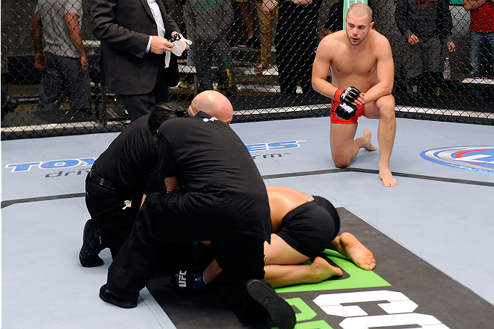 LACHUTE, CANADA - DECEMBER 6: Team Canada fighter Chad Laprise (R) kneels in the corner of the Octagon overlooking Team Canada Kajan Johnson after knocking him out in their semifinal middleweight fight during filming of The Ultimate Fighter Nations telev