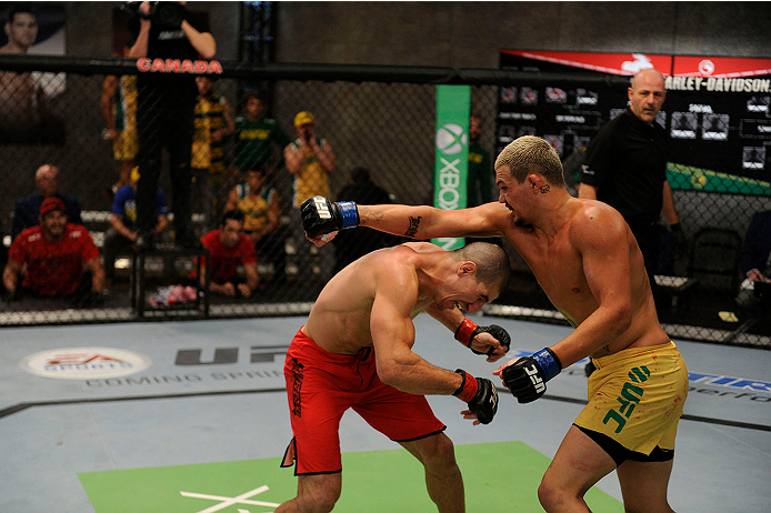LACHUTE, CANADA - NOVEMBER 11: (R-L) Team Australia fighter Tyler Manawaroa punches Team Canada fighter Nordine Taleb in their middleweight fight during filming of The Ultimate Fighter Nations television series on November 11, 2013 in Lachute, Quebec, Ca