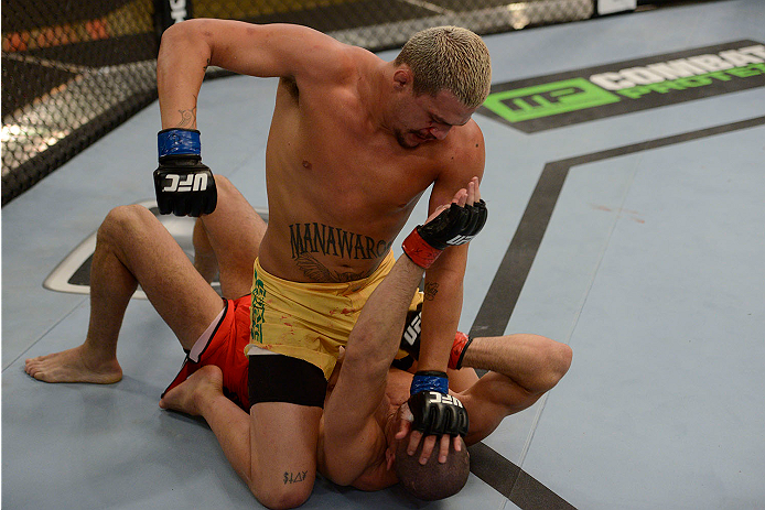 LACHUTE, CANADA - NOVEMBER 11: Team Australia fighter Tyler Manawaroa (top) punches Team Canada fighter Nordine Taleb in their middleweight fight during filming of The Ultimate Fighter Nations television series on November 11, 2013 in Lachute, Quebec, Ca