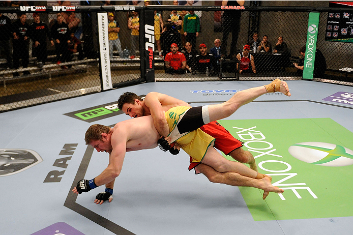 LACHUTE, CANADA - NOVEMBER 17: Team Canada fighter Sheldon Westcott (red shorts) takes down Team Australia fighter Daniel Kelly (yellow shorts) in their middleweight fight during filming of The Ultimate Fighter Nations television series on November 17, 2