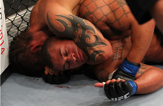 INDIANAPOLIS, IN - AUGUST 28: Abel Trujillo gives a thumbs-up signal to the referee as he defends a choke by Roger Bowling in their lightweight fight during the UFC on FOX Sports 1 event at Bankers Life Fieldhouse on August 28, 2013 in Indianapolis, Indi