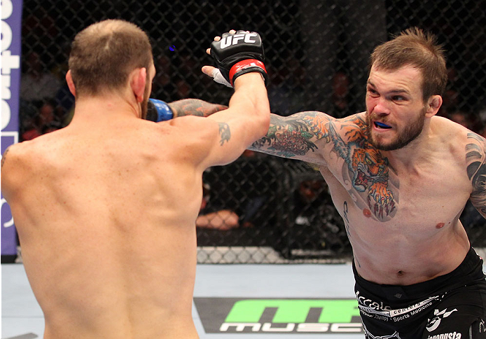 INDIANAPOLIS, IN - AUGUST 28: (R-L) Benny Alloway punches Zak Cummings in their welterweight fight during the UFC on FOX Sports 1 event at Bankers Life Fieldhouse on August 28, 2013 in Indianapolis, Indiana. (Photo by Ed Mulholland/Zuffa LLC/Zuffa LLC vi