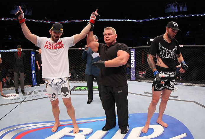 INDIANAPOLIS, IN - AUGUST 28: Zak Cummings (L) reacts after his submission victory over Benny Alloway (R) in their welterweight fight during the UFC on FOX Sports 1 event at Bankers Life Fieldhouse on August 28, 2013 in Indianapolis, Indiana. (Photo by E