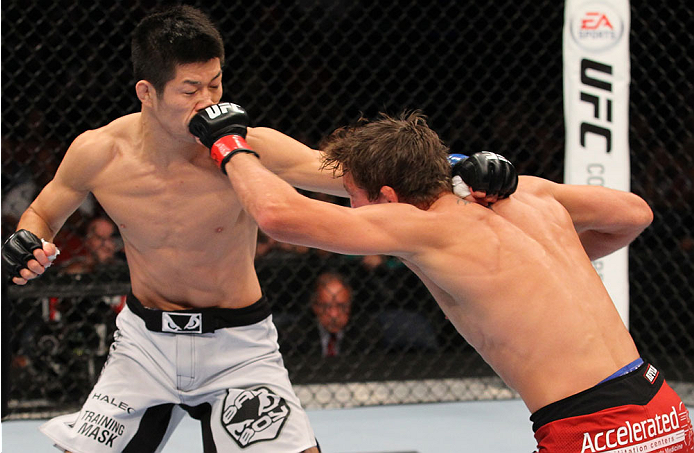 INDIANAPOLIS, IN - AUGUST 28: (R-L) Darren Elkins punches Hatsu Hioki in their featherweight fight during the UFC on FOX Sports 1 event at Bankers Life Fieldhouse on August 28, 2013 in Indianapolis, Indiana. (Photo by Ed Mulholland/Zuffa LLC/Zuffa LLC vi