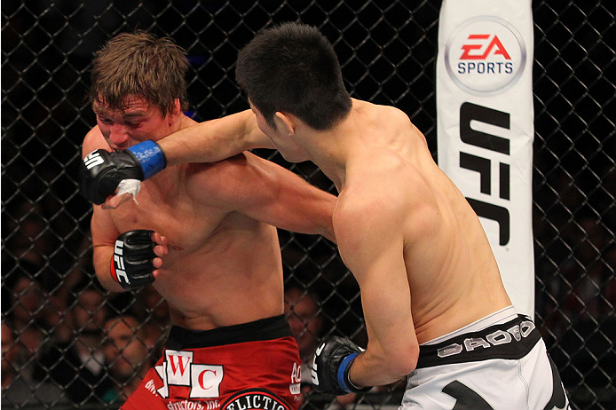 INDIANAPOLIS, IN - AUGUST 28: (R-L) Hatsu Hioki punches Darren Elkins in their featherweight fight during the UFC on FOX Sports 1 event at Bankers Life Fieldhouse on August 28, 2013 in Indianapolis, Indiana. (Photo by Ed Mulholland/Zuffa LLC/Zuffa LLC vi
