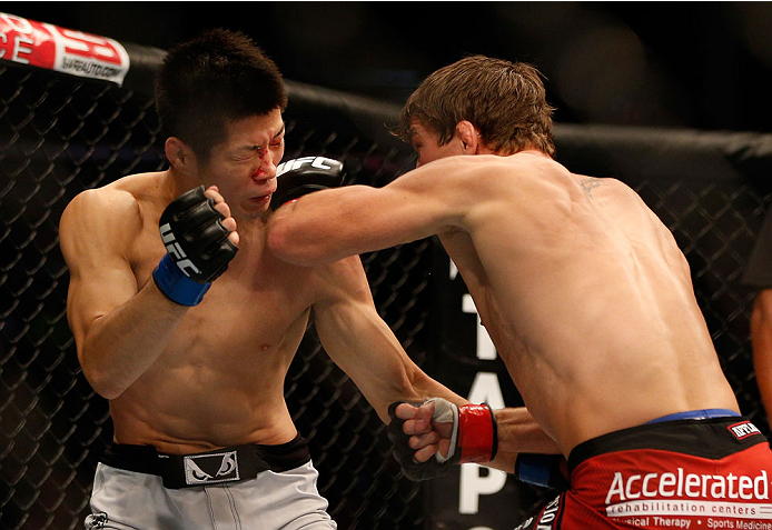 INDIANAPOLIS, IN - AUGUST 28: (R-L) Darren Elkins punches Hatsu Hioki in their featherweight fight during the UFC on FOX Sports 1 event at Bankers Life Fieldhouse on August 28, 2013 in Indianapolis, Indiana. (Photo by Josh Hedges/Zuffa LLC/Zuffa LLC via