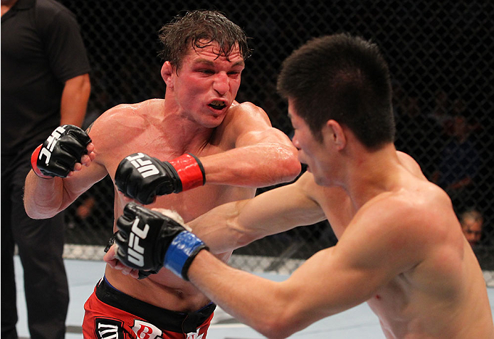INDIANAPOLIS, IN - AUGUST 28: (L-R) Darren Elkins punches Hatsu Hioki in their featherweight fight during the UFC on FOX Sports 1 event at Bankers Life Fieldhouse on August 28, 2013 in Indianapolis, Indiana. (Photo by Ed Mulholland/Zuffa LLC/Zuffa LLC vi
