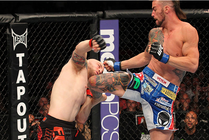 INDIANAPOLIS, IN - AUGUST 28: (R-L) Brandon Thatch knees Justin Edwards in their welterweight fight during the UFC on FOX Sports 1 event at Bankers Life Fieldhouse on August 28, 2013 in Indianapolis, Indiana. (Photo by Ed Mulholland/Zuffa LLC/Zuffa LLC v