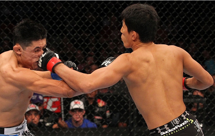 INDIANAPOLIS, IN - AUGUST 28: (R-L) Takeya Mizugaki punches Erik Perez in their bantamweight fight during the UFC on FOX Sports 1 event at Bankers Life Fieldhouse on August 28, 2013 in Indianapolis, Indiana. (Photo by Ed Mulholland/Zuffa LLC/Zuffa LLC vi