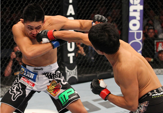 INDIANAPOLIS, IN - AUGUST 28: (R-L) Takeya Mizugaki punches Erik Perez in their bantamweight fight during the UFC on FOX Sports 1 event at Bankers Life Fieldhouse on August 28, 2013 in Indianapolis, Indiana. (Photo by Ed Mulholland/Zuffa LLC/Zuffa LLC vi