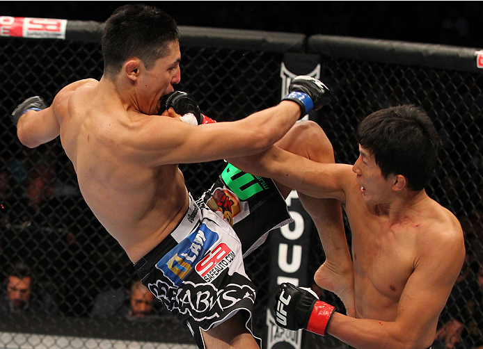INDIANAPOLIS, IN - AUGUST 28: (R-L) Takeya Mizugaki punches Erik Perez in their bantamweight fight during the UFC on FOX Sports 1 event at Bankers Life Fieldhouse on August 28, 2013 in Indianapolis, Indiana. (Photo by Ed Mulholland/Zuffa LLC/Zuffa LLC vi