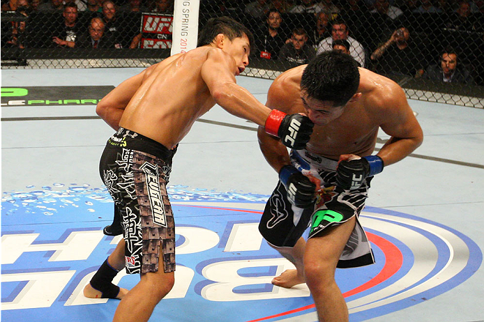 INDIANAPOLIS, IN - AUGUST 28: (L-R) Takeya Mizugaki punches Erik Perez in their bantamweight fight during the UFC on FOX Sports 1 event at Bankers Life Fieldhouse on August 28, 2013 in Indianapolis, Indiana. (Photo by Ed Mulholland/Zuffa LLC/Zuffa LLC vi