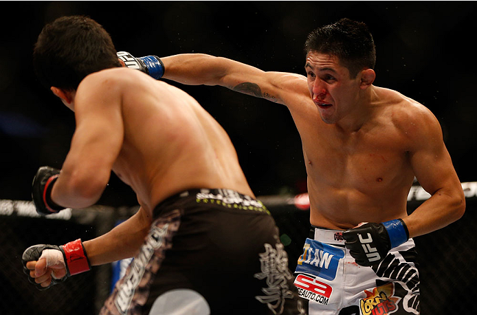 INDIANAPOLIS, IN - AUGUST 28: (R-L) Erik Perez punches Takeya Mizugaki in their bantamweight fight during the UFC on FOX Sports 1 event at Bankers Life Fieldhouse on August 28, 2013 in Indianapolis, Indiana. (Photo by Josh Hedges/Zuffa LLC/Zuffa LLC via
