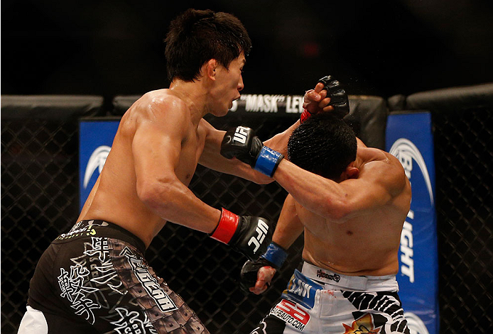 INDIANAPOLIS, IN - AUGUST 28: (L-R) Takeya Mizugaki punches Erik Perez in their bantamweight fight during the UFC on FOX Sports 1 event at Bankers Life Fieldhouse on August 28, 2013 in Indianapolis, Indiana. (Photo by Josh Hedges/Zuffa LLC/Zuffa LLC via