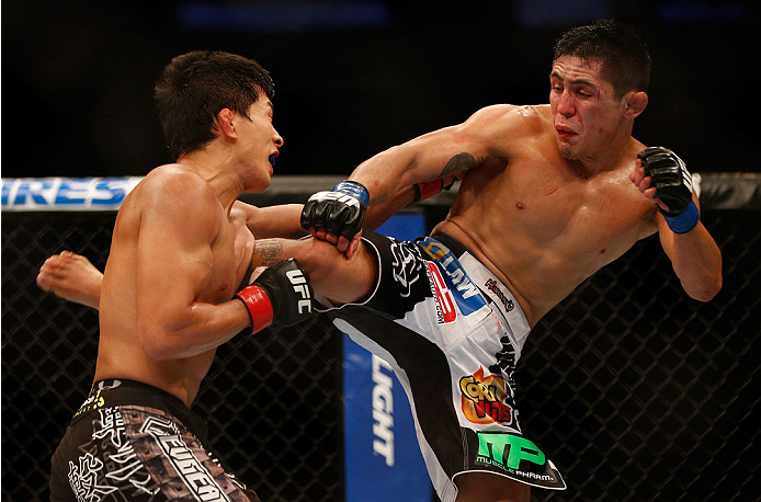 INDIANAPOLIS, IN - AUGUST 28: (R-L) Erik Perez kicks Takeya Mizugaki in their bantamweight fight during the UFC on FOX Sports 1 event at Bankers Life Fieldhouse on August 28, 2013 in Indianapolis, Indiana. (Photo by Josh Hedges/Zuffa LLC/Zuffa LLC via Ge