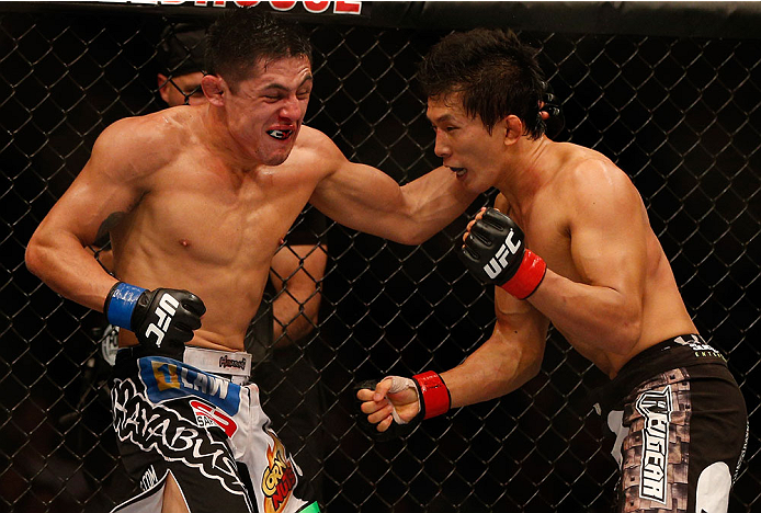 INDIANAPOLIS, IN - AUGUST 28: (L-R) Erik Perez punches Takeya Mizugaki in their bantamweight fight during the UFC on FOX Sports 1 event at Bankers Life Fieldhouse on August 28, 2013 in Indianapolis, Indiana. (Photo by Josh Hedges/Zuffa LLC/Zuffa LLC via