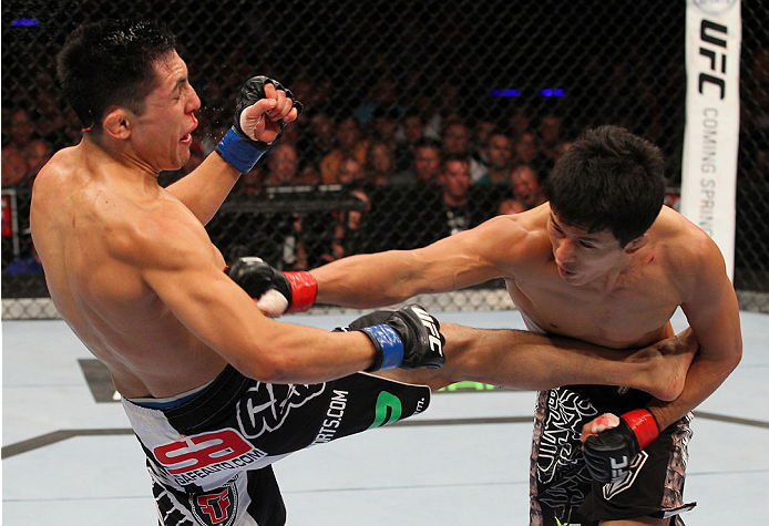 INDIANAPOLIS, IN - AUGUST 28: (R-L) Takeya Mizugaki punches Erik Perez in their bantamweight fight during the UFC on FOX Sports 1 event at Bankers Life Fieldhouse on August 28, 2013 in Indianapolis, Indiana. (Photo by Ed Mulholland/Zuffa LLC/Zuffa LLC vi
