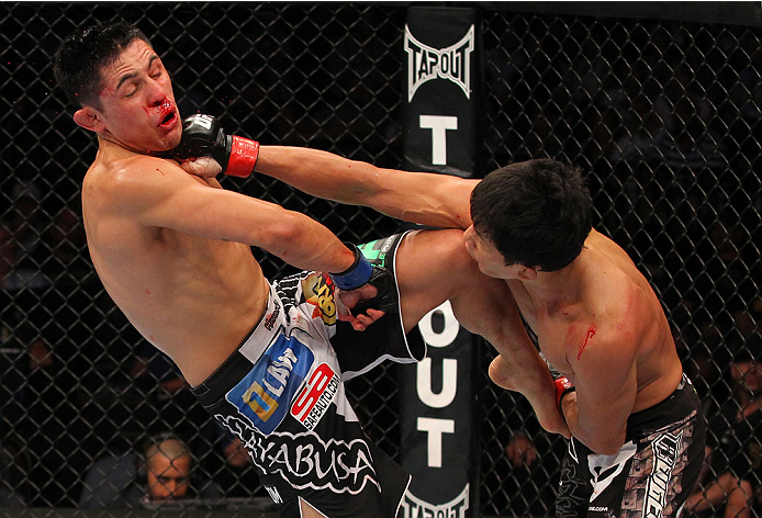 INDIANAPOLIS, IN - AUGUST 28: (R-L) Takeya Mizugaki punches Erik Perez in their bantamweight fight during the UFC on FOX Sports 1 event at Bankers Life Fieldhouse on August 28, 2013 in Indianapolis, Indiana. (Photo by Ed Mulholland/Zuffa LLC/Zuffa LLC vi