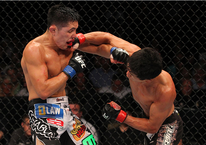 INDIANAPOLIS, IN - AUGUST 28: (R-L) Takeya Mizugaki punches Erik Perez in their bantamweight fight during the UFC on FOX Sports 1 event at Bankers Life Fieldhouse on August 28, 2013 in Indianapolis, Indiana. (Photo by Ed Mulholland/Zuffa LLC/Zuffa LLC vi
