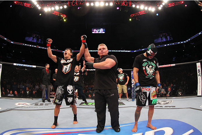INDIANAPOLIS, IN - AUGUST 28: Takeya Mizugaki (L) reacts after his victory over Erik Perez (R) in their bantamweight fight during the UFC on FOX Sports 1 event at Bankers Life Fieldhouse on August 28, 2013 in Indianapolis, Indiana. (Photo by Ed Mulhollan