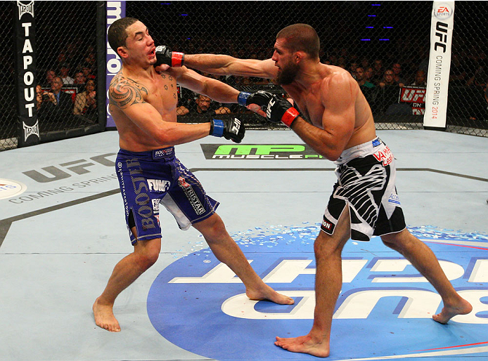 INDIANAPOLIS, IN - AUGUST 28: (R-L) Court McGee punches Robert Whittaker in their welterweight fight during the UFC on FOX Sports 1 event at Bankers Life Fieldhouse on August 28, 2013 in Indianapolis, Indiana. (Photo by Ed Mulholland/Zuffa LLC/Zuffa LLC