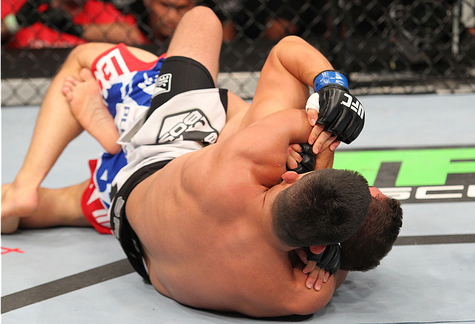 INDIANAPOLIS, IN - AUGUST 28: (L-R) Kelvin Gastelum secures a rear choke submission against Brian Melancon in their welterweight fight during the UFC on FOX Sports 1 event at Bankers Life Fieldhouse on August 28, 2013 in Indianapolis, Indiana. (Photo by