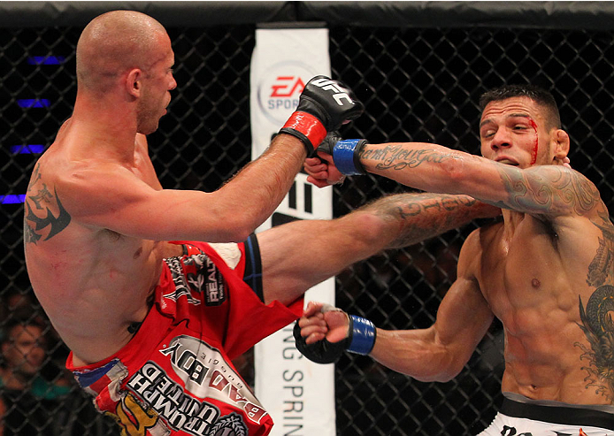 INDIANAPOLIS, IN - AUGUST 28: (L-R) Donald "Cowboy" Cerrone kicks Rafael dos Anjos in their lightweight fight during the UFC on FOX Sports 1 event at Bankers Life Fieldhouse on August 28, 2013 in Indianapolis, Indiana. (Photo by Ed Mulholland/Zuffa LLC/Z